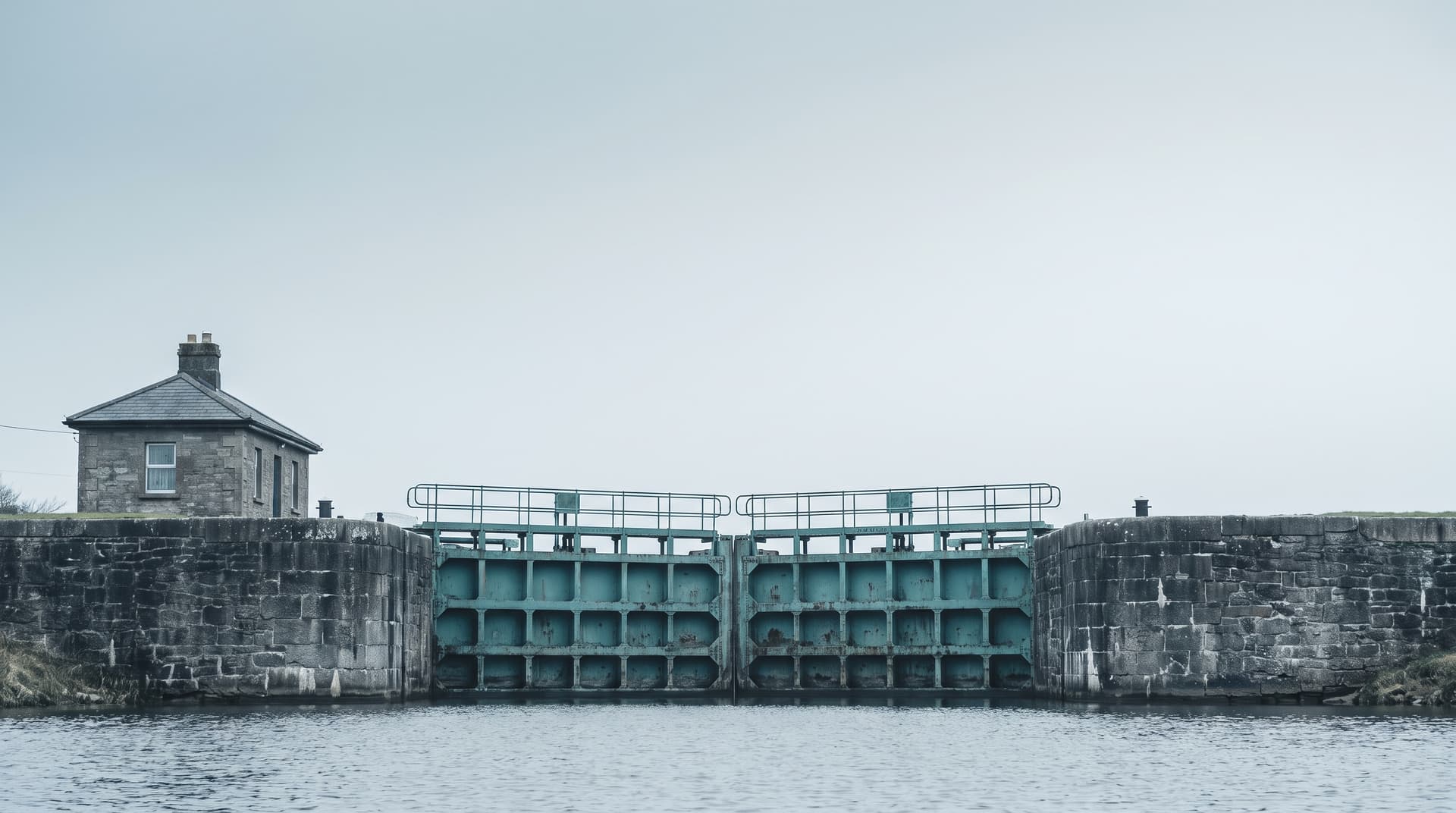 Canal lock with a teal-painted steel gate between stone walls under an overcast sky – a visual metaphor for the controlled connection of language models