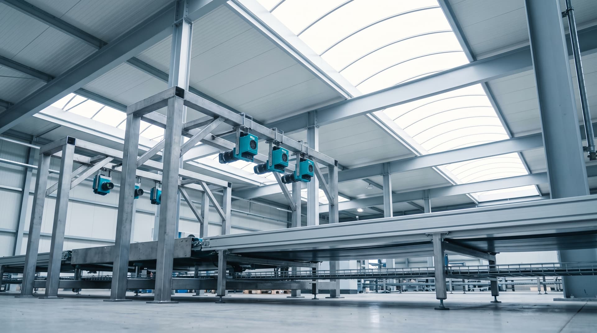 Inspektionsportal mit Industriekameras über einem Förderband in einer hellen Fabrikhalle, von unten fotografiert