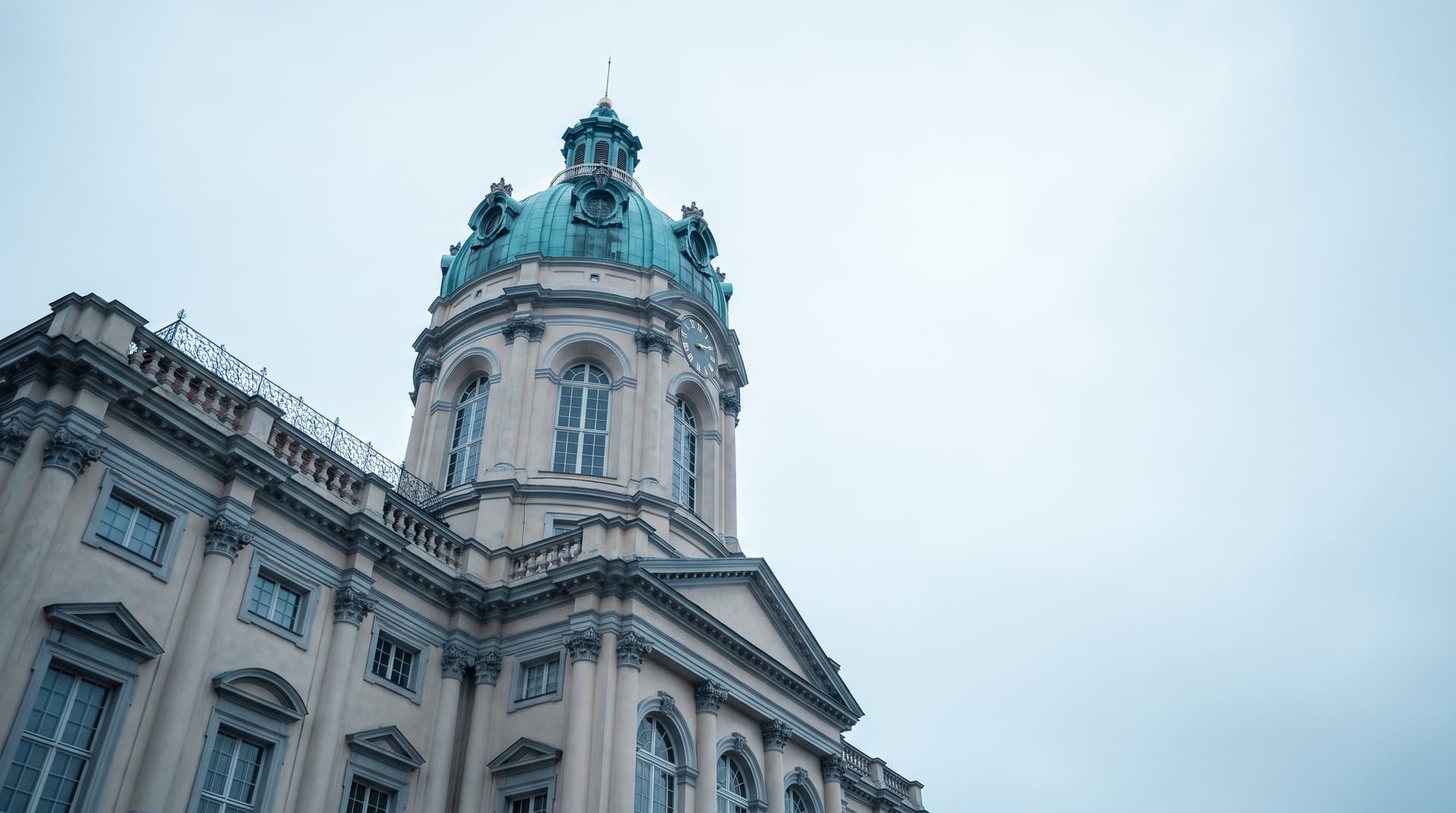 Mittelturm von Schloss Charlottenburg in Berlin von unten fotografiert, Kuppel aus grün patiniertem Kupfer vor hellem Himmel