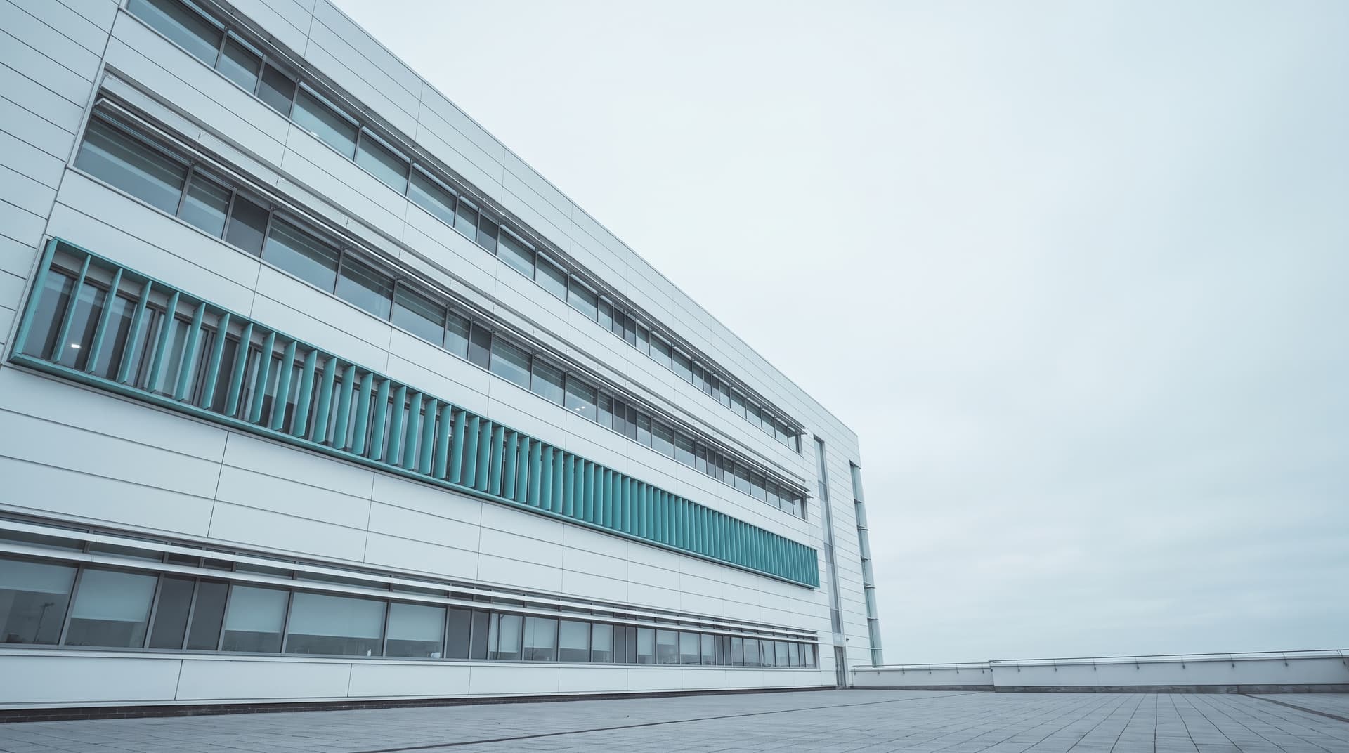 Moderno edificio ospedaliero con finestre a nastro fotografato dal basso, frangisole di un piano color verde acqua